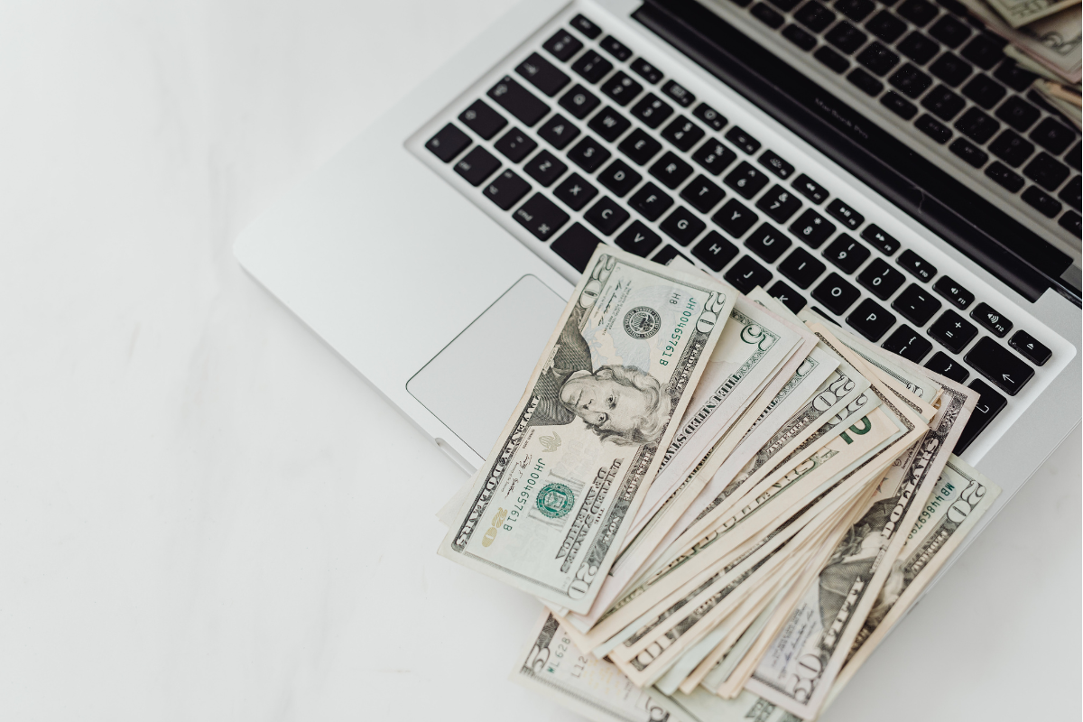 Computer with money laying across the keyboard.